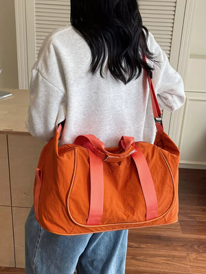 Orange lightweight Oxford cloth duffel bag with dual straps and side pocket.