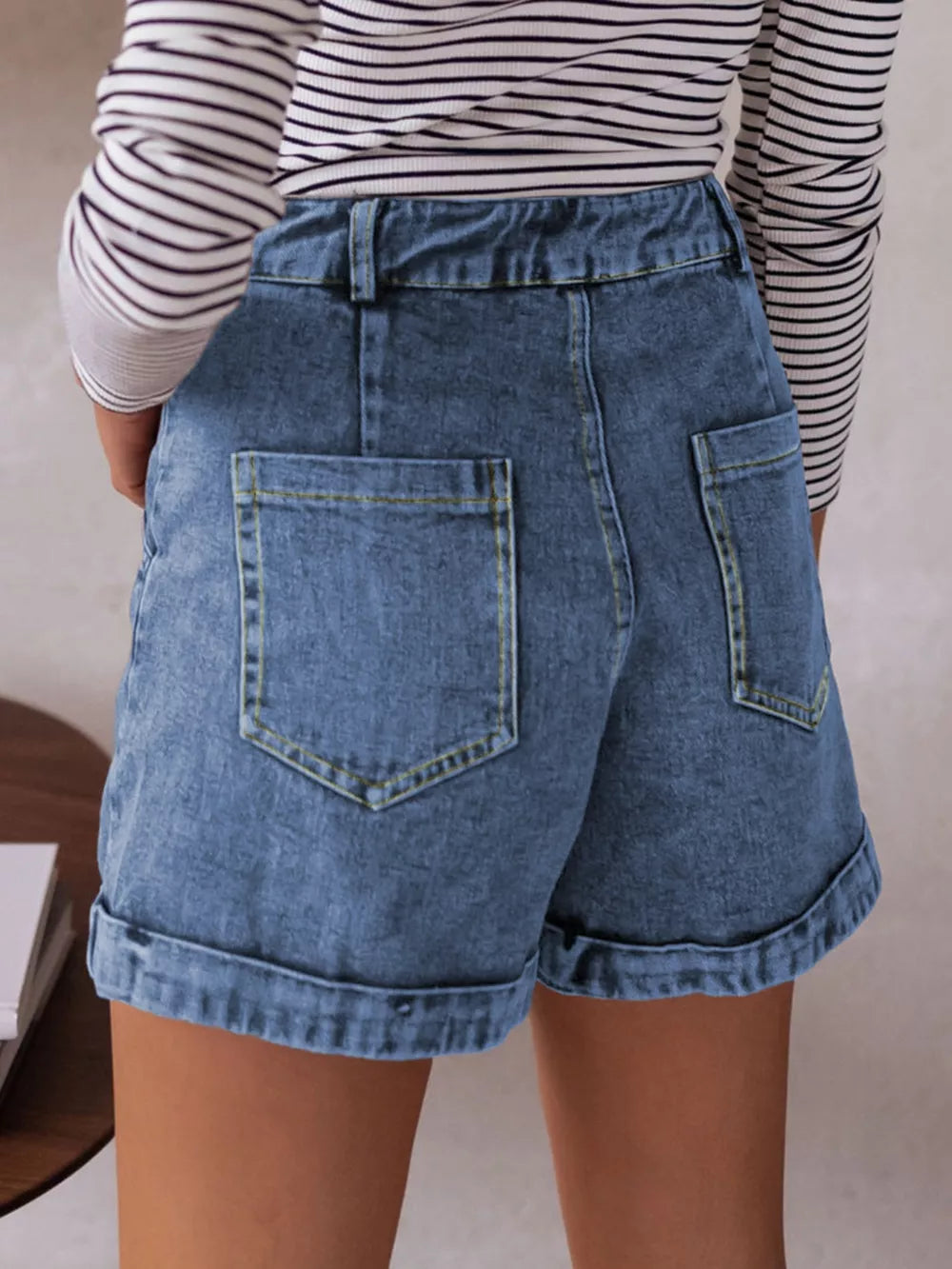 Blue cuffed denim shorts with buttoned fly and back pockets.