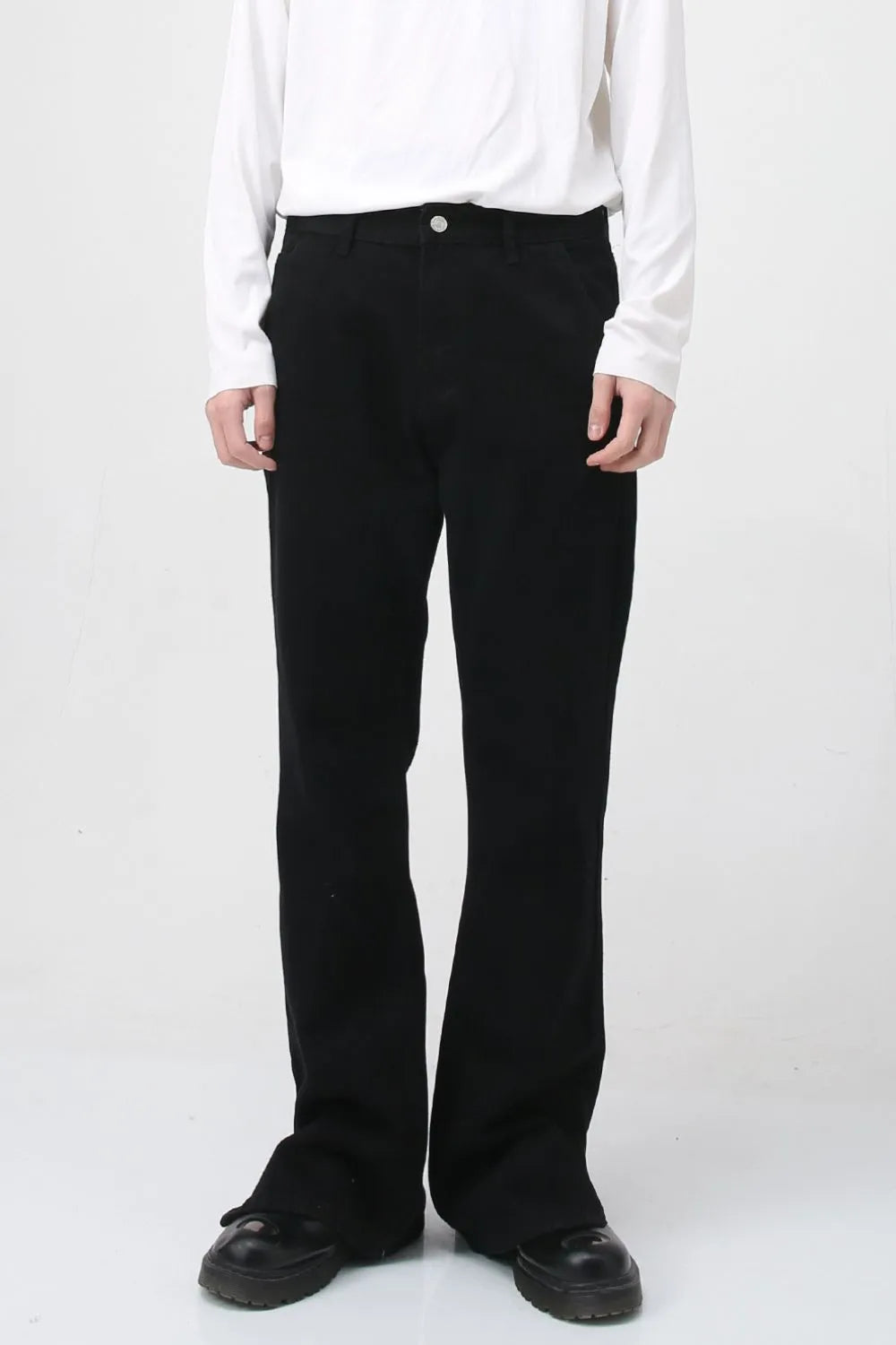 Flared hem denim trousers in dark cotton, styled casually.