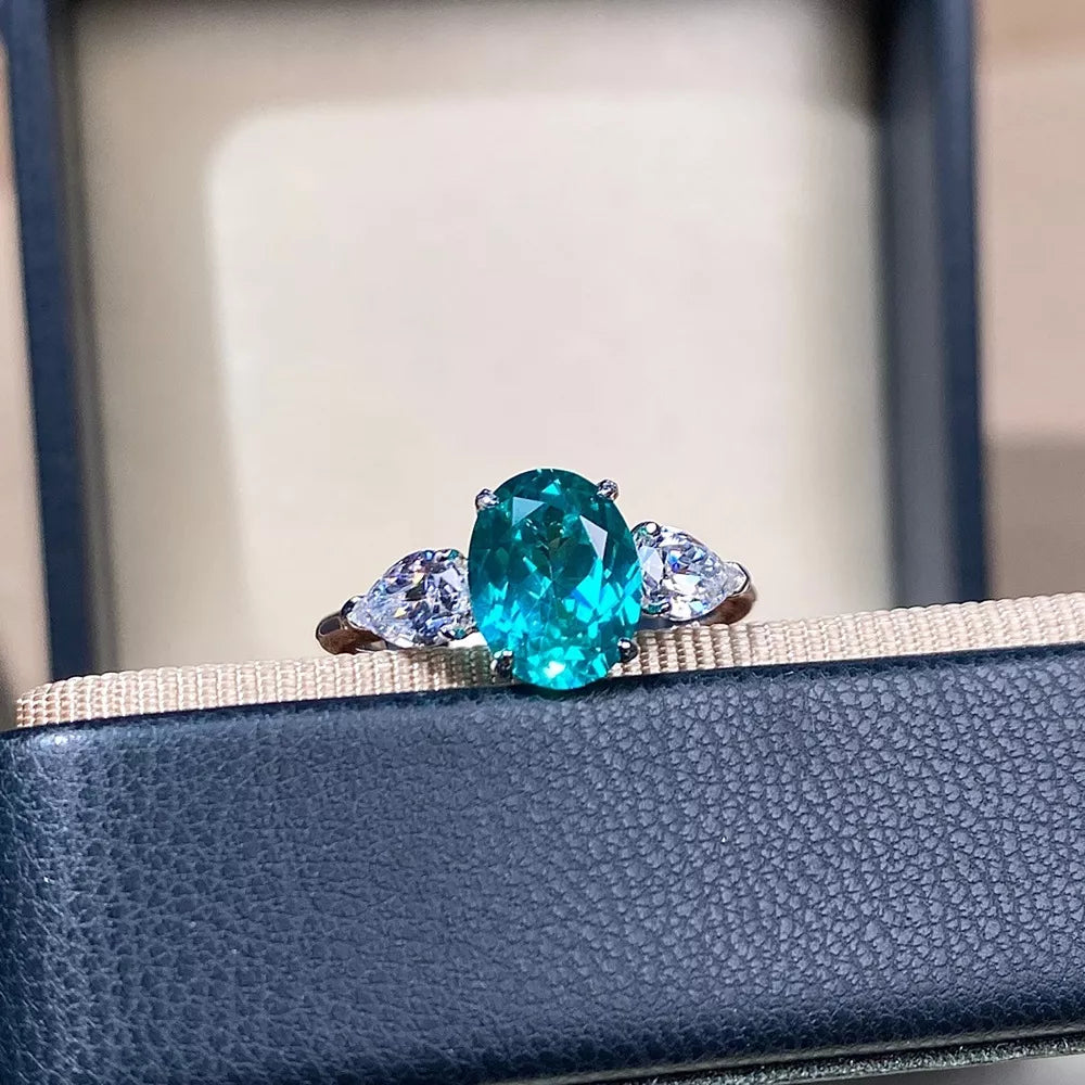 ring in teal featuring gemstone setting and three-stone oval and pear fit