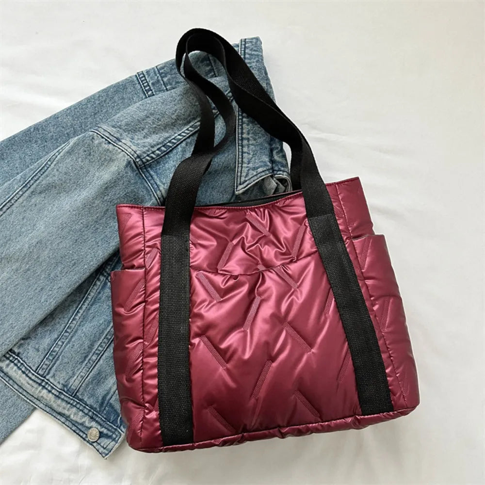 Padded nylon tote bag in deep red with exterior pockets and black straps.