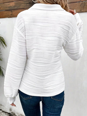 White textured quarter zip pullover with a collared neckline and long sleeves.
