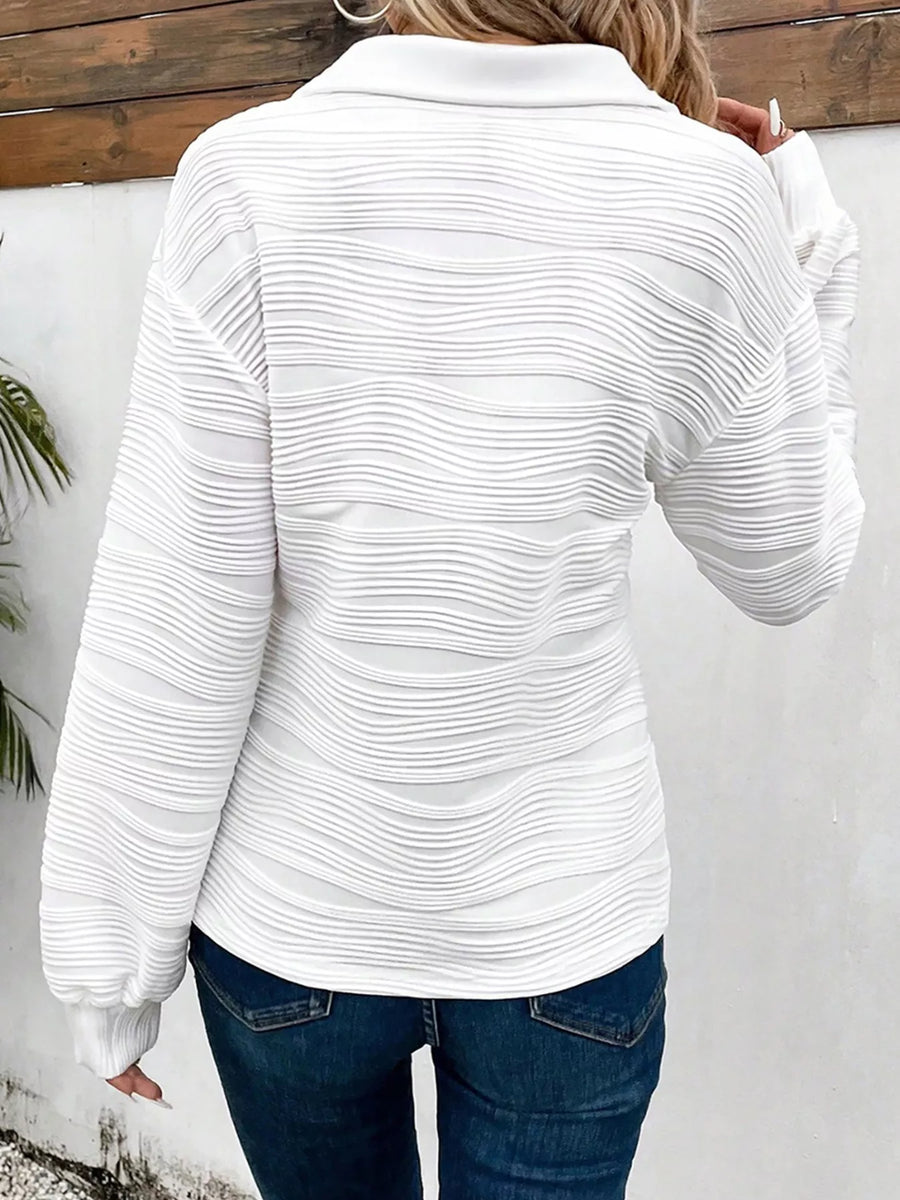 White textured quarter zip pullover with a collared neckline and long sleeves.