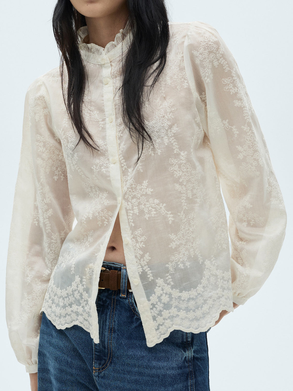 Sheer apricot button-down blouse with floral embroidery and ruffled collar.