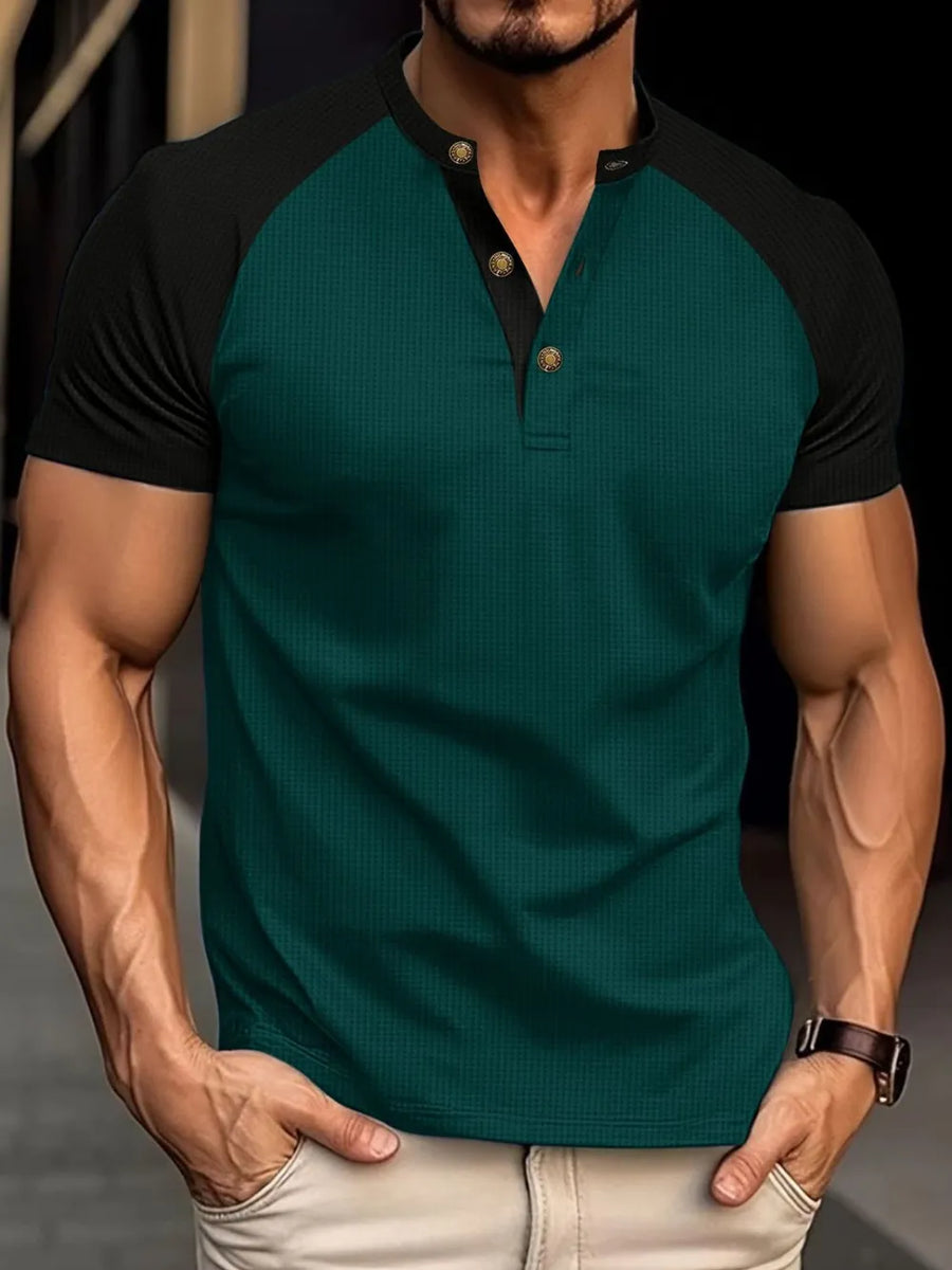 Dark green raglan henley polo shirt with black sleeves and gold button detail
