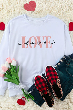 White crewneck sweatshirt with pink "love" script graphic.