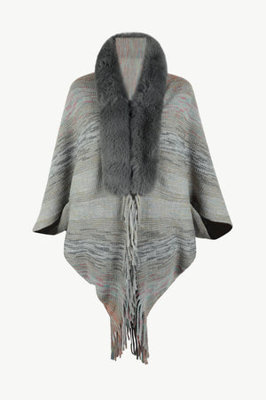 Textured knit cape with faux fur collar and fringe detail.
