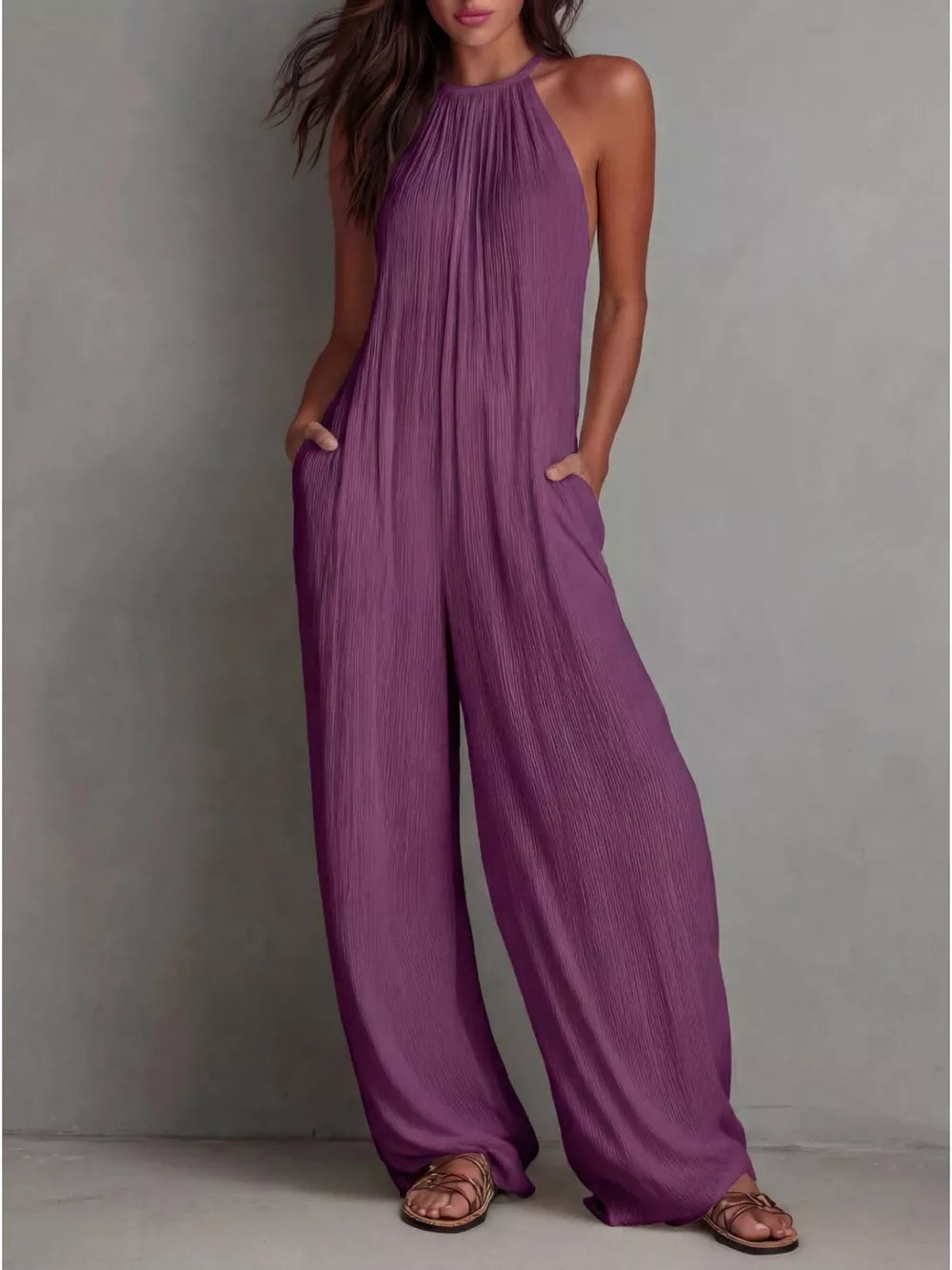 Purple wide-leg jumpsuit with halter neck and textured fabric.