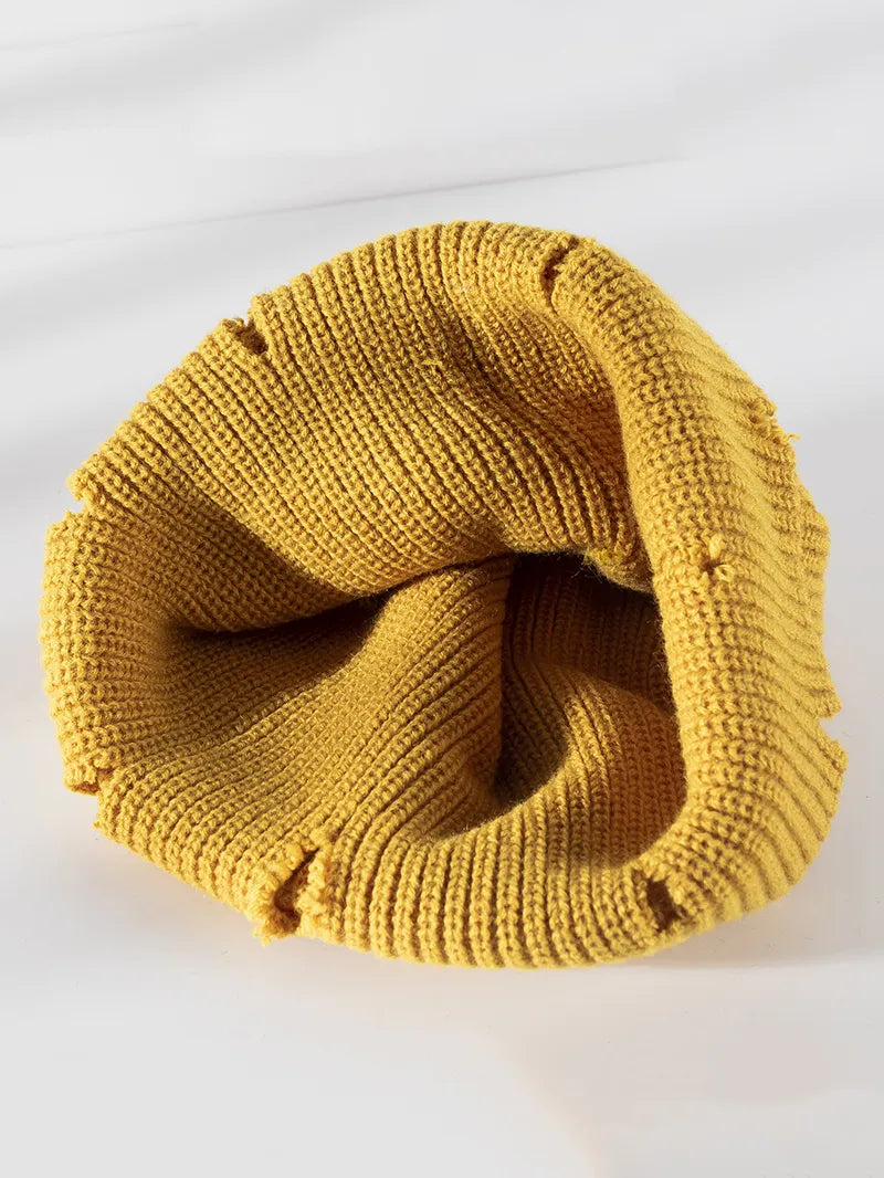 Yellow ribbed knit beanie with distressed details and a casual cut.