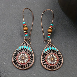 Bohemian mandala drop earrings in copper with turquoise and red accents, featuring beaded detail.