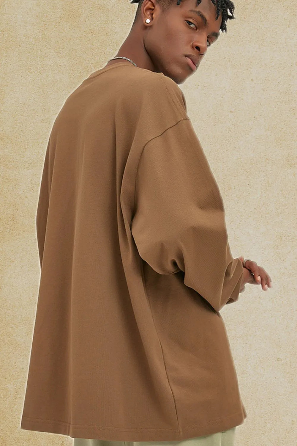 Oversized drop-shoulder crewneck pullover in camel, made of 100% cotton.