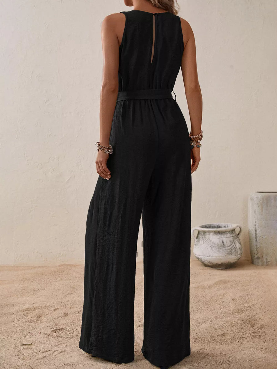 Black V-neck tie-waist wide-leg romper with button-down detail and textured fabric.