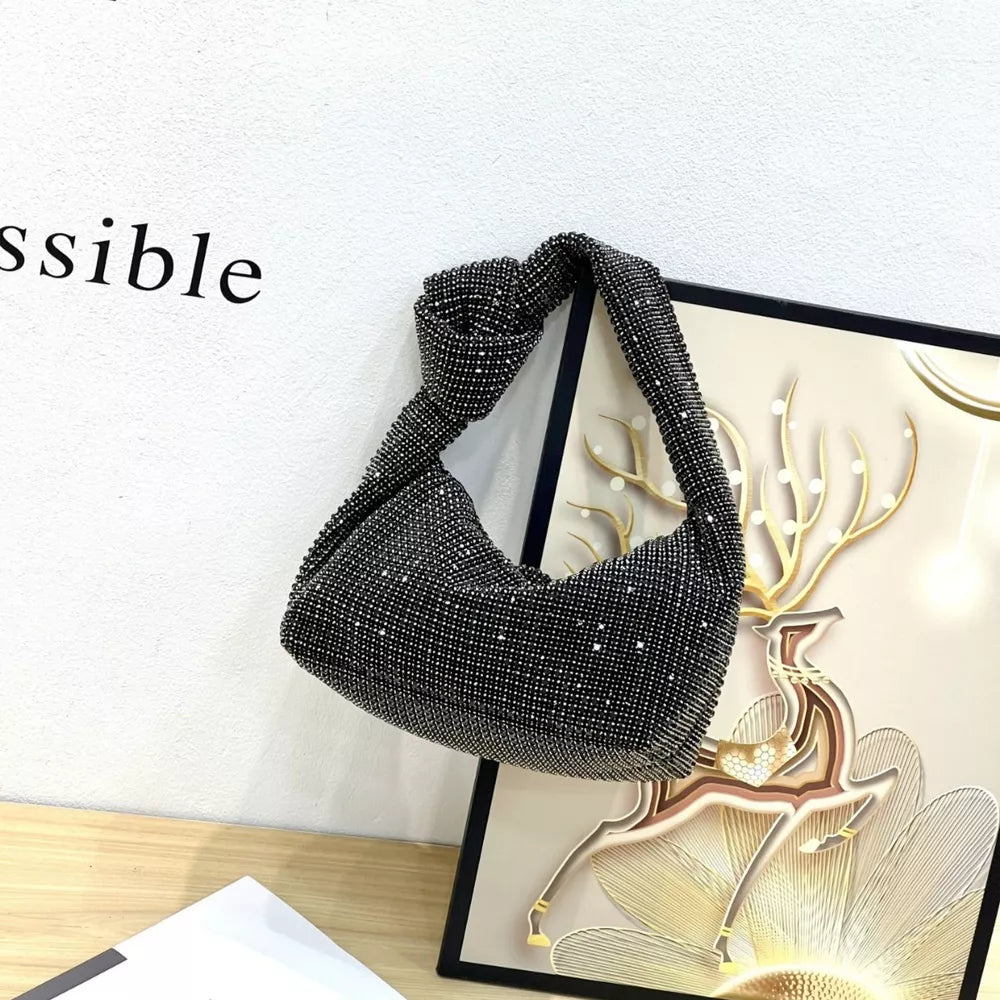 Black crescent tote bag covered in rhinestones with a knotted strap.