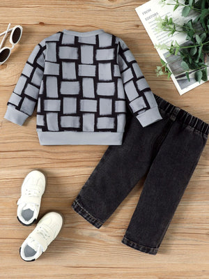 Childrens grey long sleeve top with black block pattern and black jeans.