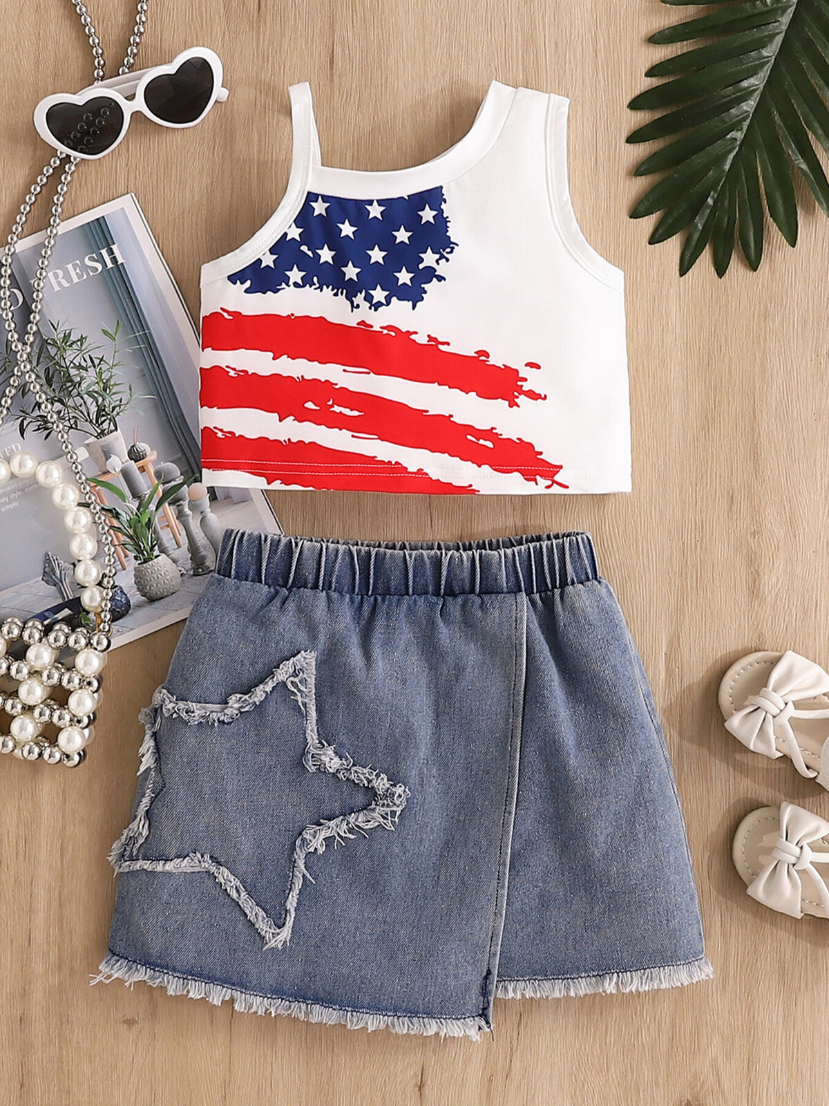 Patriotic two-piece set with American flag tank top and distressed denim skirt with star detail.