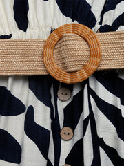 Belted dress with tropical leaf print, raffia belt, and decorative buttons.