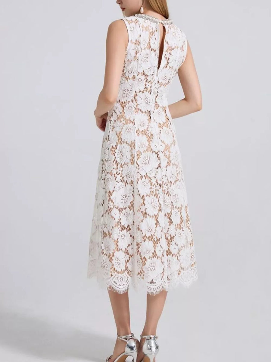 White lace midi dress with floral pattern, embellished neckline, and sleeveless cut.