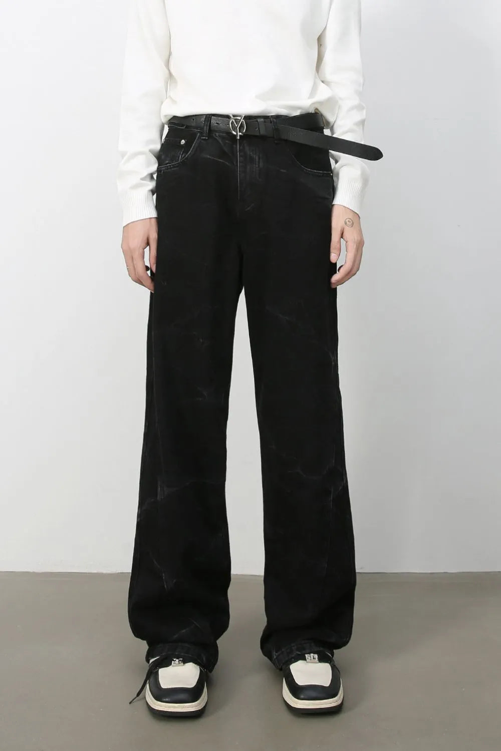 Faded black wide-leg denim jeans with subtle marble-like distressing.