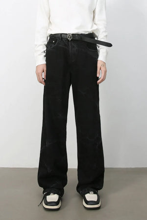 Faded black wide-leg denim jeans with subtle marble-like distressing.