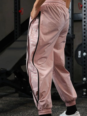 Dusty Pink track pants with full side zip detail and reflective logo.