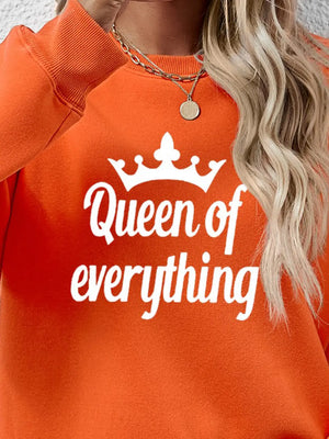 Orange graphic sweatshirt with white Queen of Everything text and crown detail.