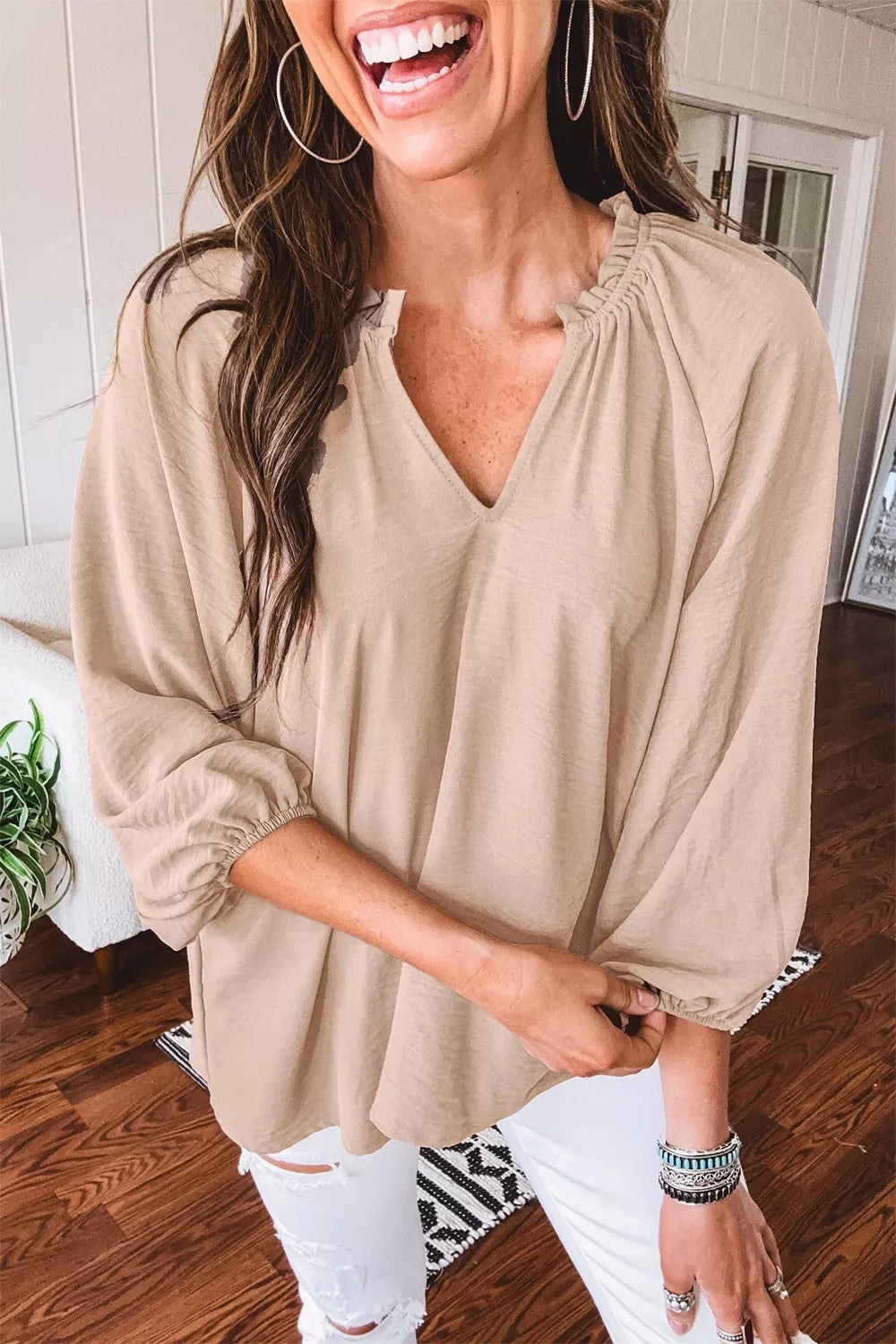Beige peasant blouse with V-neck and ruffled neckline, balloon sleeves.