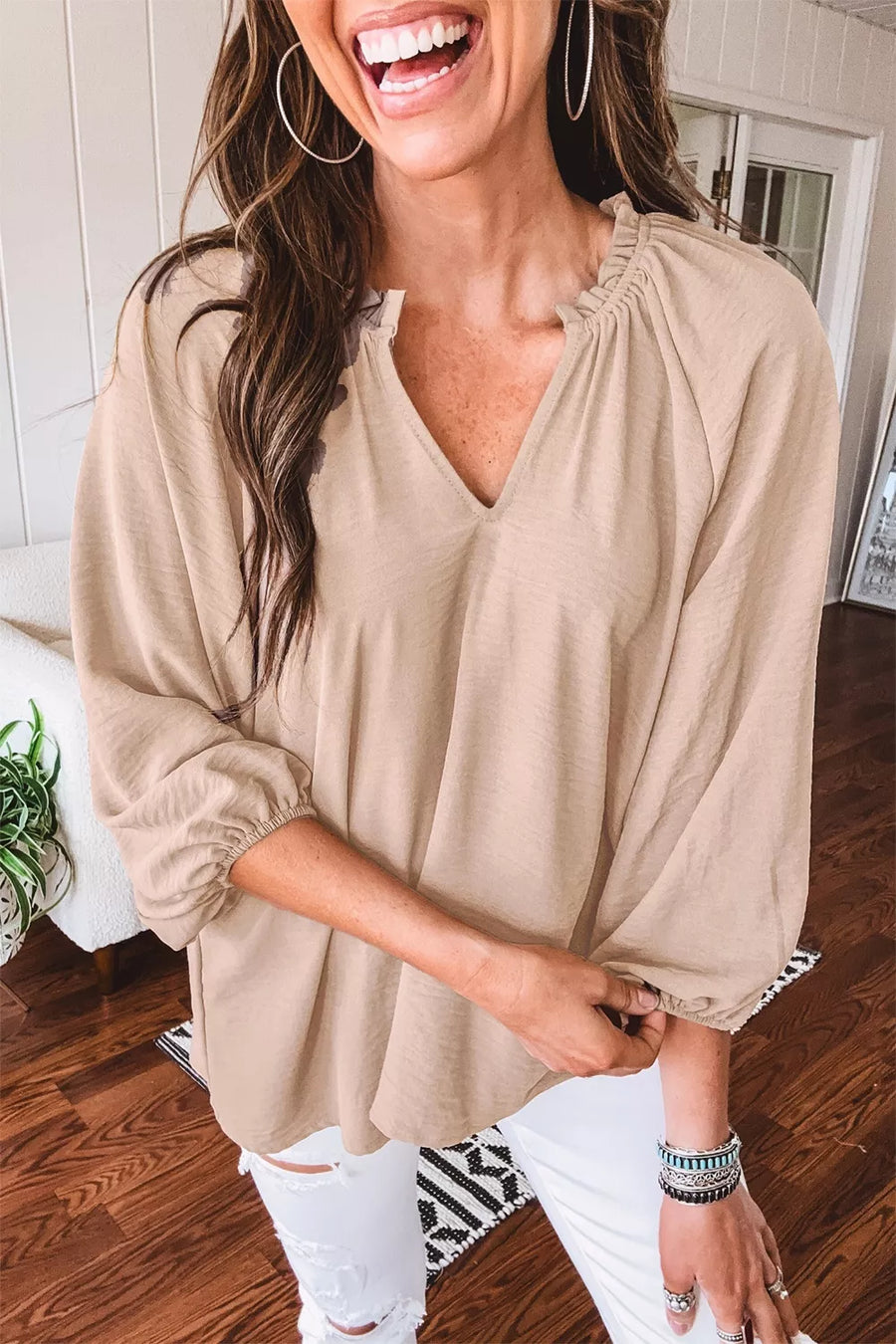Beige peasant blouse with V-neck and ruffled neckline, balloon sleeves.