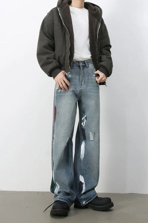 Ink-Blot Wide Leg Denim jeans in medium wash with abstract paint splatters and distressed details.