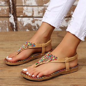 Beige thong sandals with colorful beadwork and elastic ankle strap.