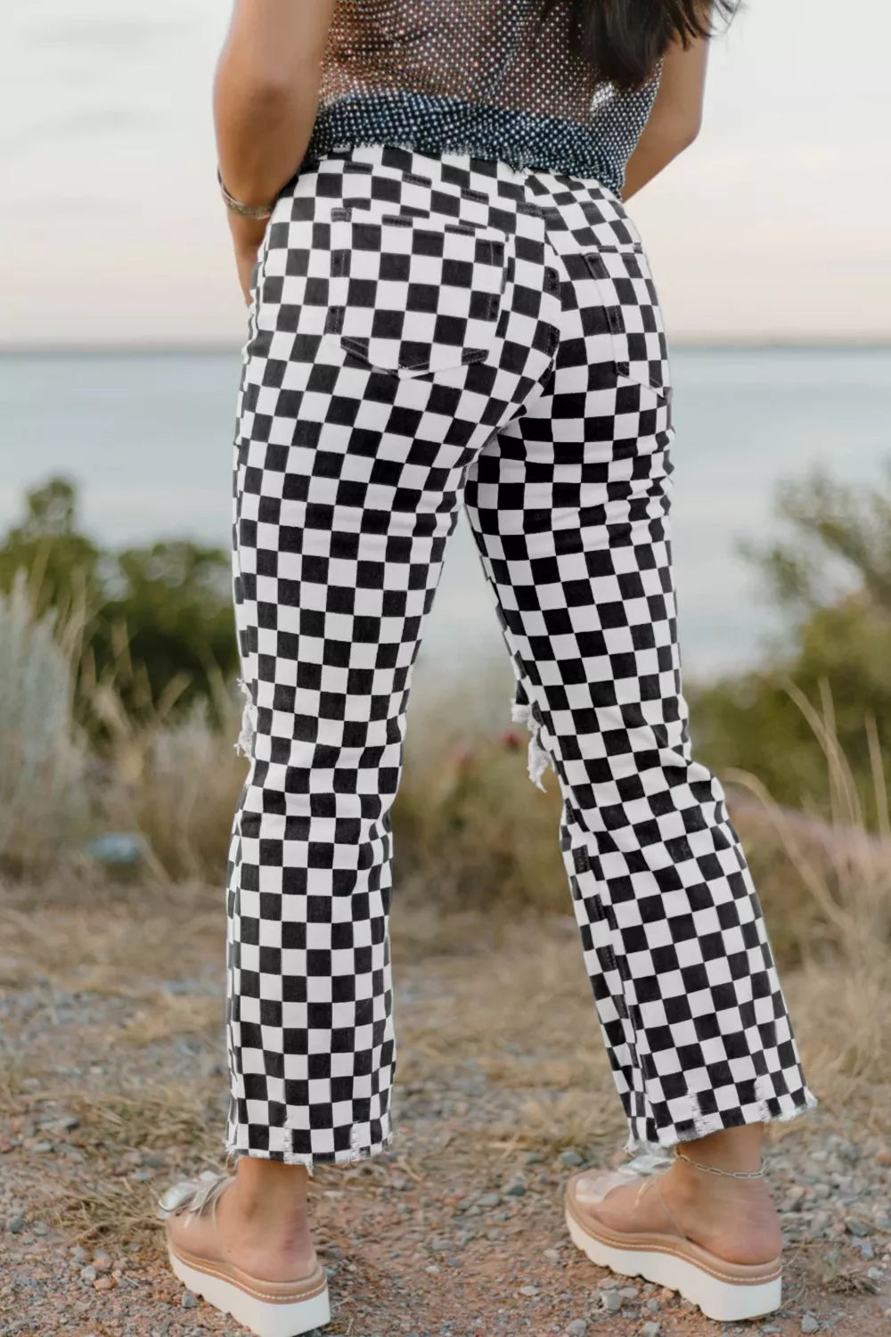 Checkerboard distressed cropped jeans in black and white denim with ripped details.