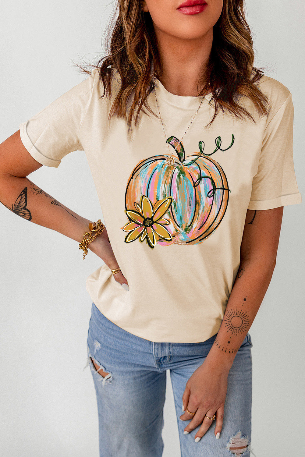 Sand t-shirt with a colorful painted pumpkin and flower graphic, crew neck, short sleeves.