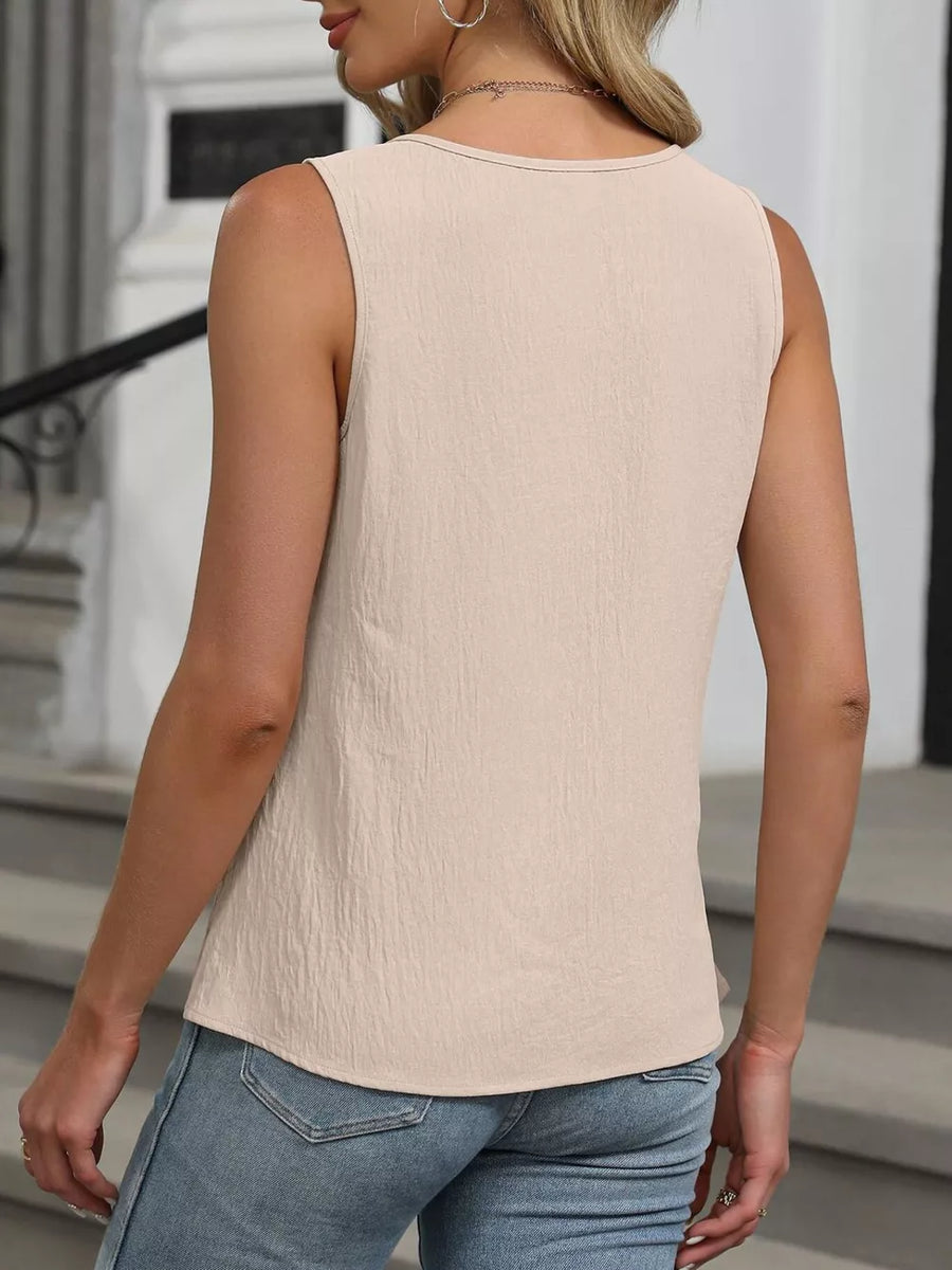Sleeveless apricot tank top with a textured fabric and round neckline.