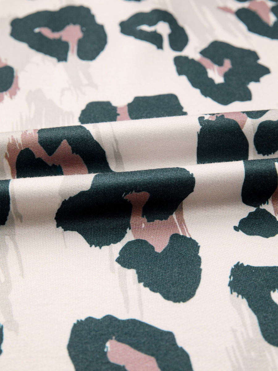 Print short sleeve blouse with abstract animal print in green, pink, and beige on white.
