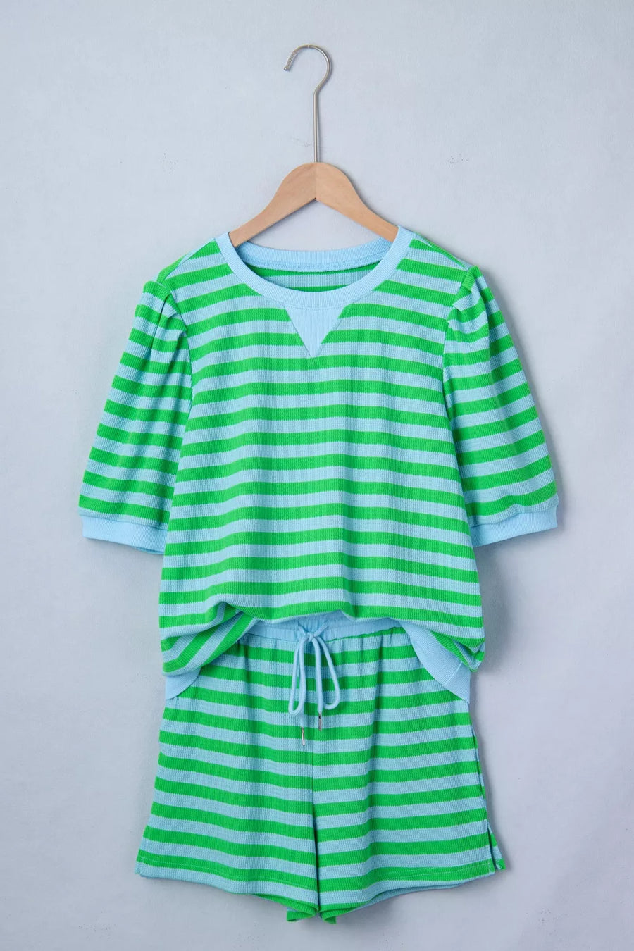 Striped knit pajama set with green and blue horizontal stripes, featuring a crew neck top and drawstring shorts.