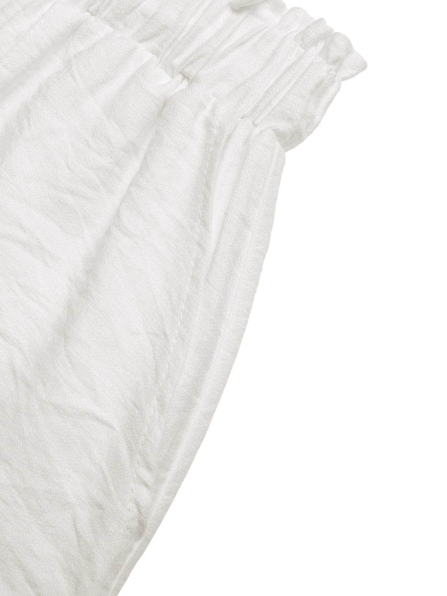 White crinkled fabric shorts with drawstring waist and lace trim detail.
