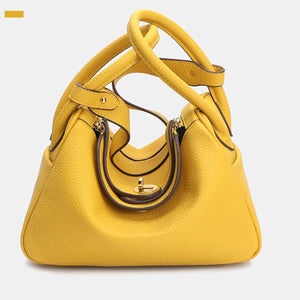 handbag in bright yellow featuring top handles and rounded fit