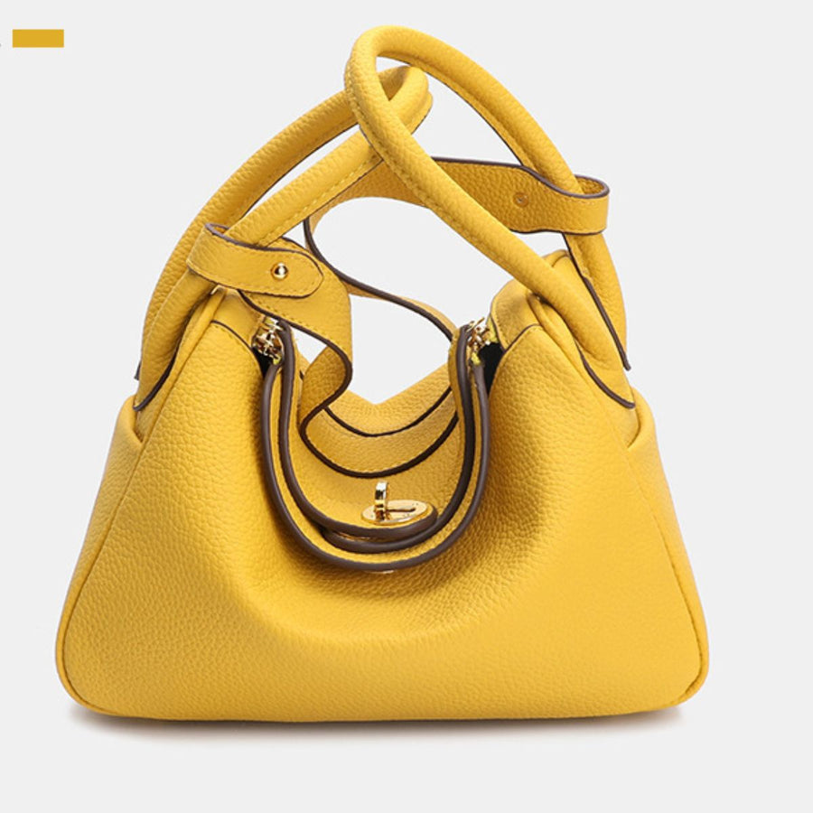 handbag in bright yellow featuring top handles and rounded fit