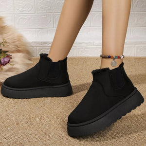 Black suede round toe platform ankle boots with fur trim and elastic side panels.