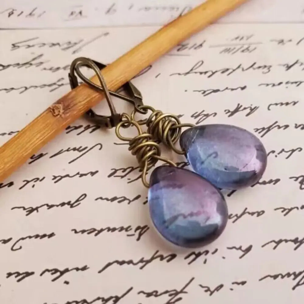 Wrapped wire teardrop earrings in blue purple with antique brass findings.
