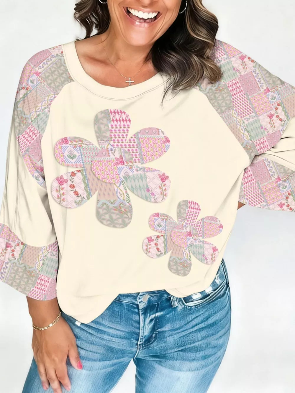 Cream long-sleeve shirt with floral patchwork on the front and sleeves, crew neck.
