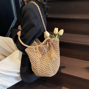 Khaki handbag featuring tassel accents and crochet