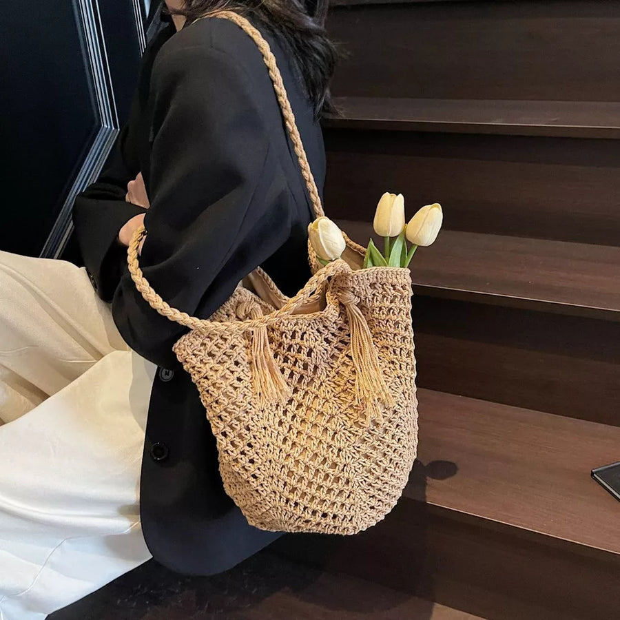 Khaki handbag featuring tassel accents and crochet