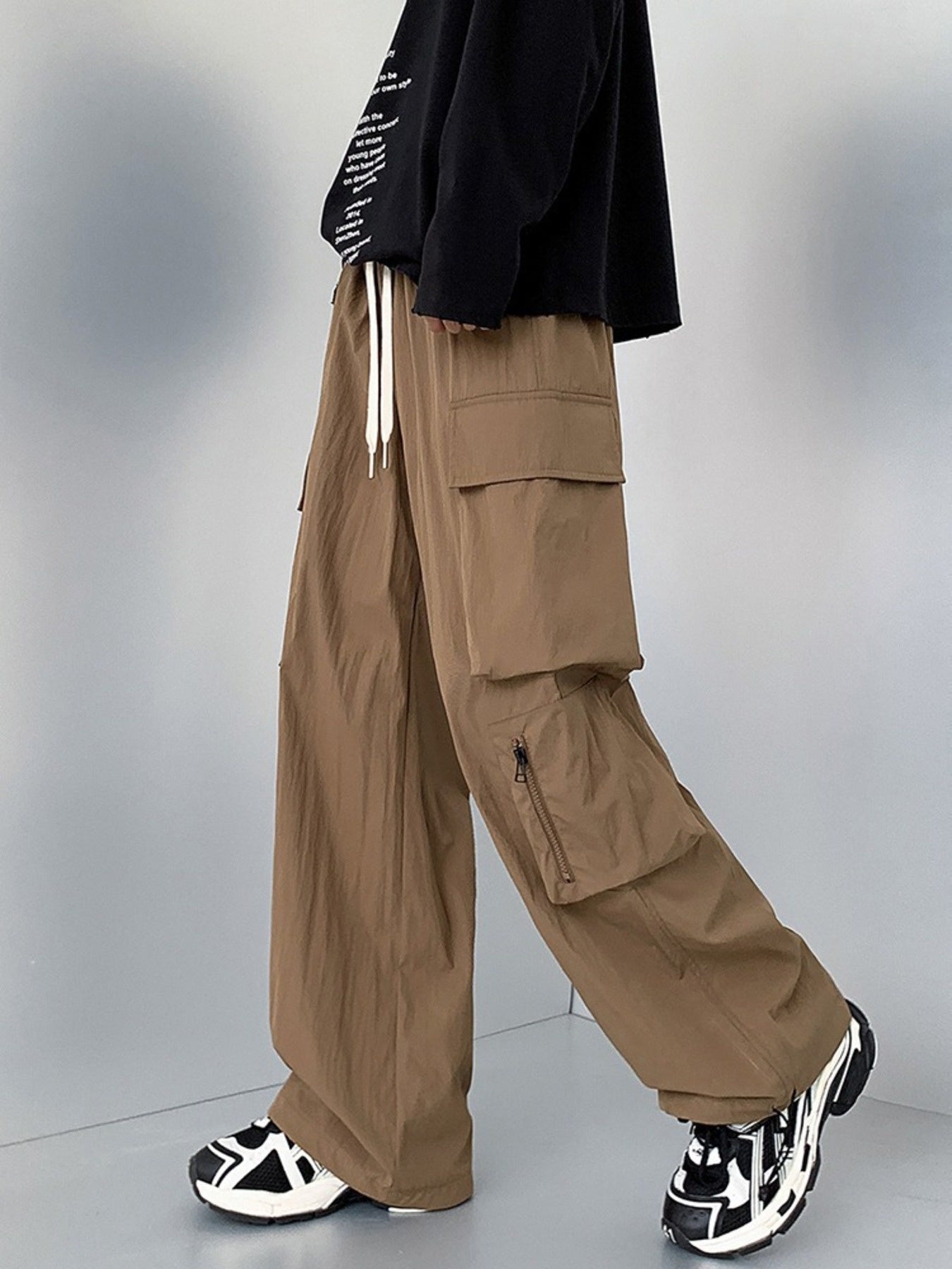 Men's camel cargo sweatpants with drawstring and zippered pockets.