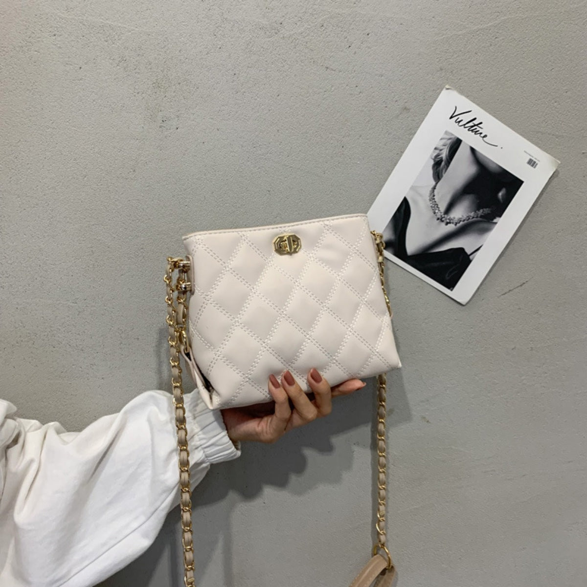 White quilted crossbody bag with diamond pattern and gold chain strap