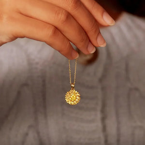 Gold sunflower pendant necklace with intricate petal detail on a delicate chain.