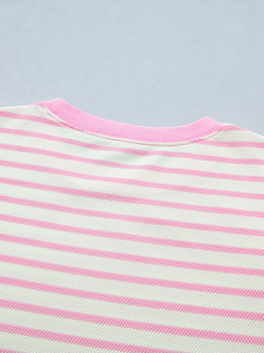 Ruffled short-sleeve blouse in white and pink stripes with a pink neckline.