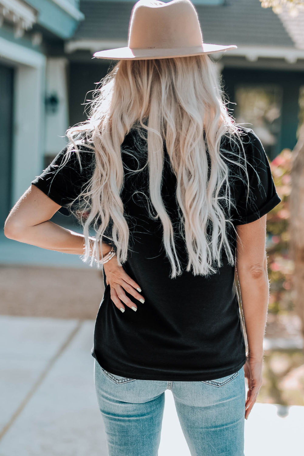 Black Vibe City t-shirt with rolled sleeves, styled with light wash jeans and a hat.