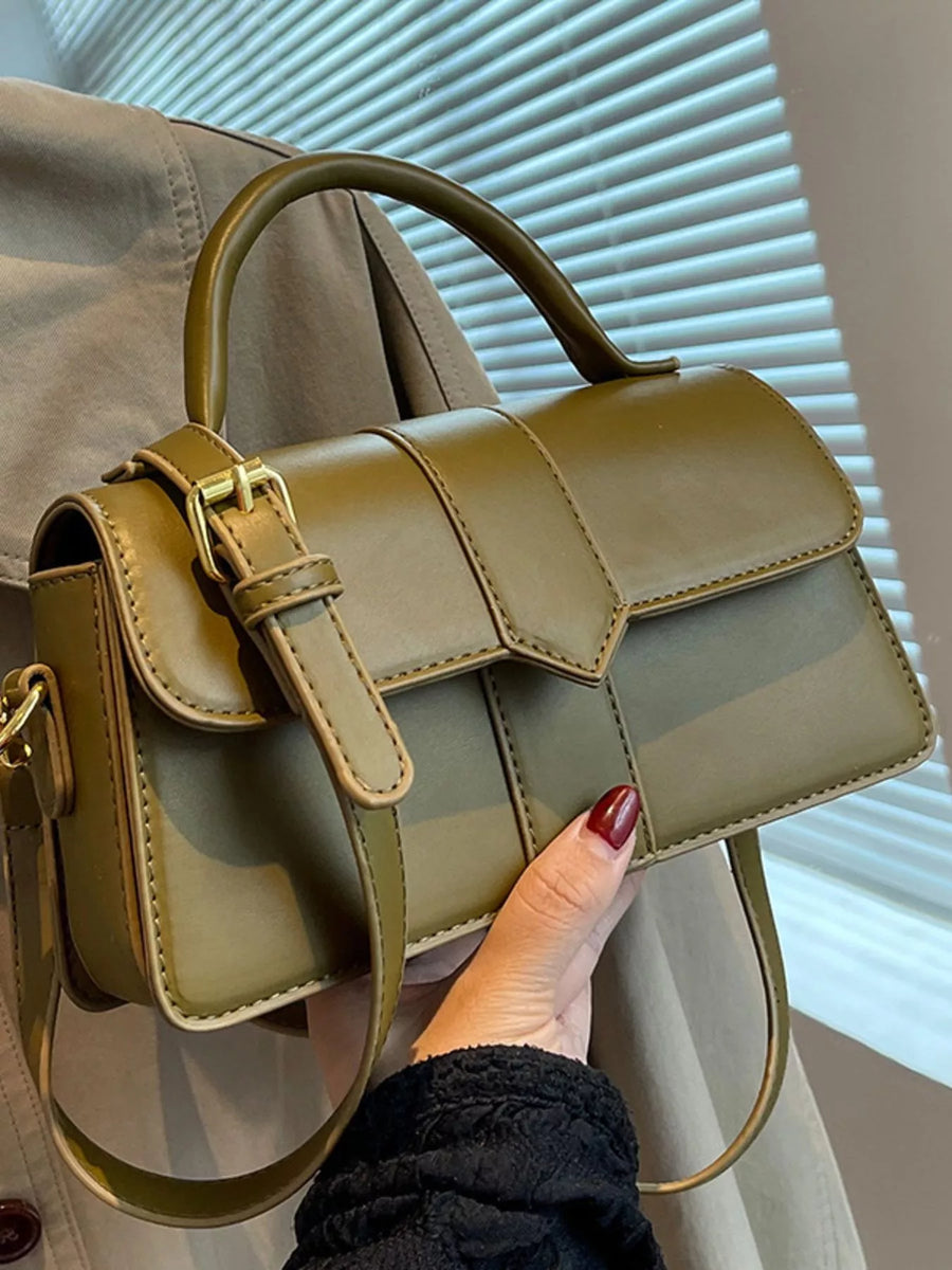 Chic small top handle bag in green with gold buckle detail and adjustable strap.