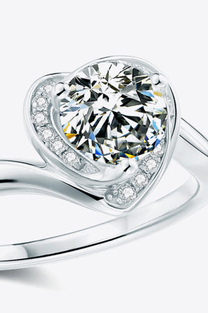 Silver moissanite ring with a heart-shaped halo and round center stone.