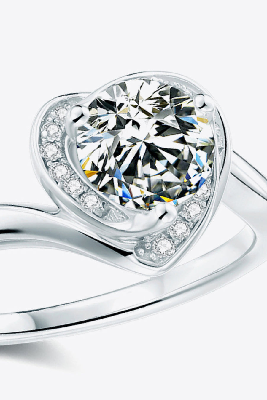 Silver moissanite ring with a heart-shaped halo and round center stone.